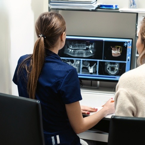 Dental team members looking at digital x rays