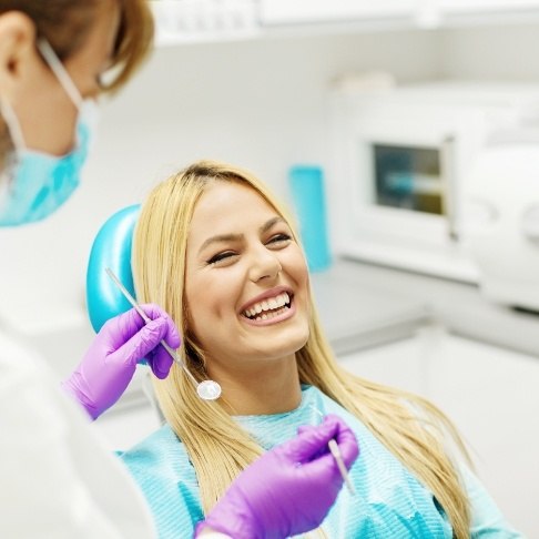 Woman in dental chair laughing