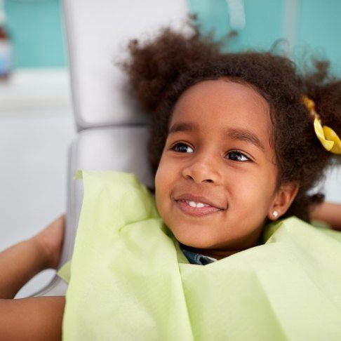 Child smiling during children's dentistry checkup and teeth cleaning