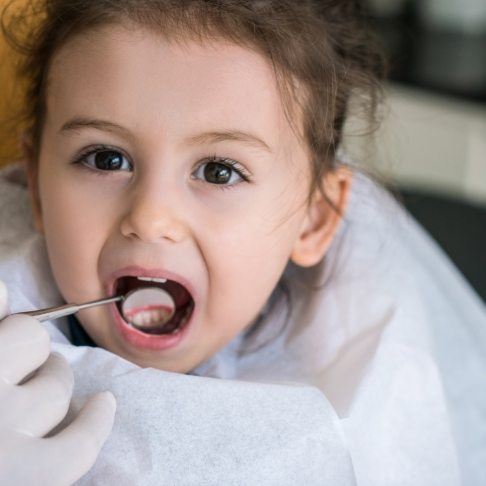 Dentist examining child's smile after dental sealant application