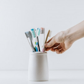 Hand reaches for toothbrush
