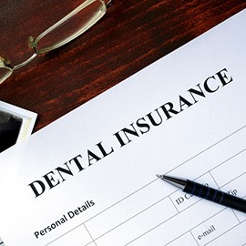 Dental insurance paperwork on desk with X-ray, money, and glasses