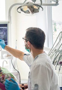 a dentist presenting an X ray to a patient near Highland Park